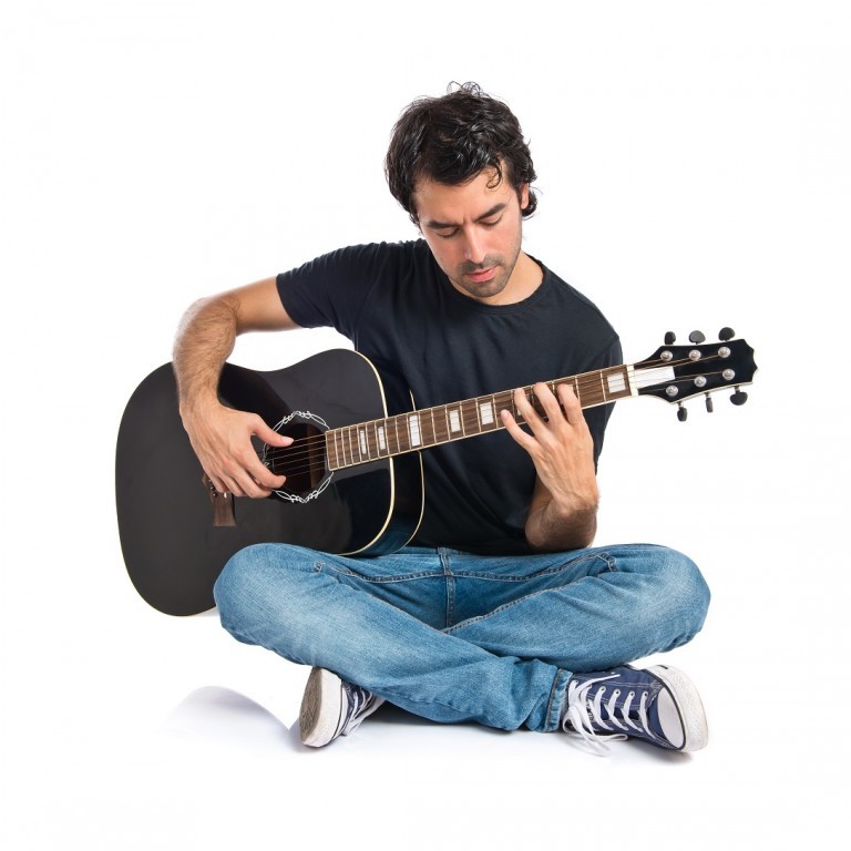 Handsome man with guitar over white background